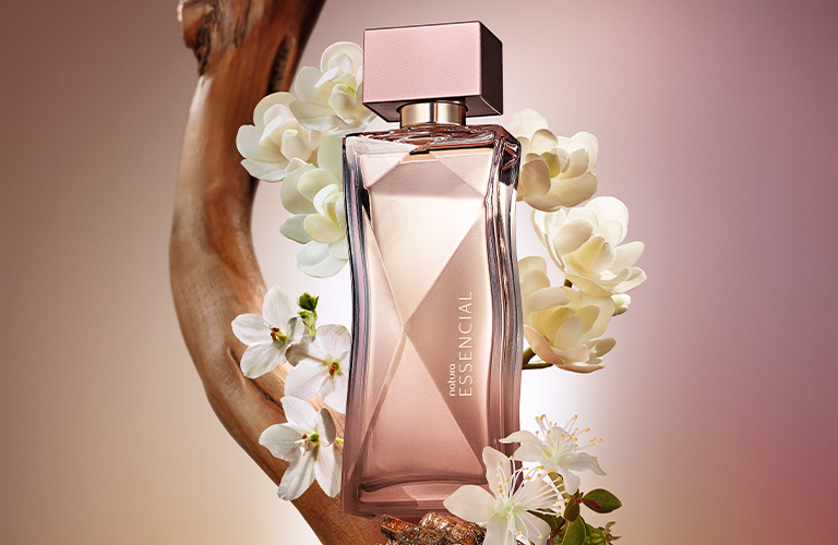 Imagen de un frasco de Essencial Elixir de Natura. El frasco tiene un diseño geométrico en tonos dorados y marrones, con una tapa cuadrada oscura.